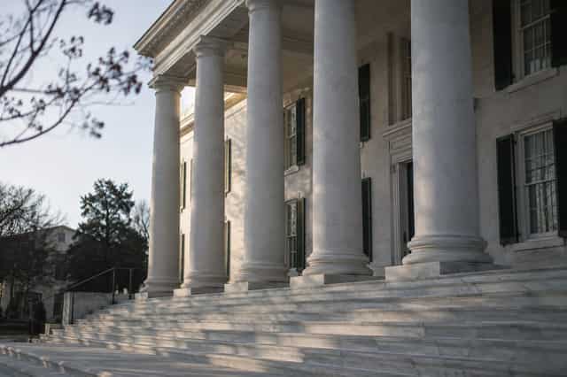 White columned portico and marble steps of a Georgia county courthouse, empty in morning light